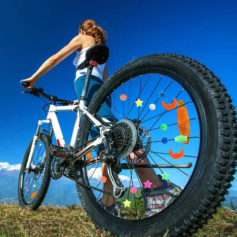Colorful Bike Spoke Beads Kit For Kids on a mountain bike wheel with assorted shapes under blue sky