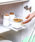 No Sweat Self Adhesive Drawer Slides Four Pack in use with transparent drawer holding white containers in cabinet.