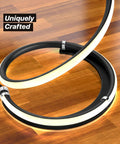 Close-up of the base of Dope 37 Inch LED Spiral Floor Lamp With Curved Modern Design showing spiral and jet-black finish on wooden floor.