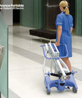 Nurse moving electric portable patient lift with folding design in hallway