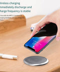 Slick Auto Rising Desk Power Strip With Fast Wireless Charger Tempered Glass Top charging smartphone on a wireless pad.
