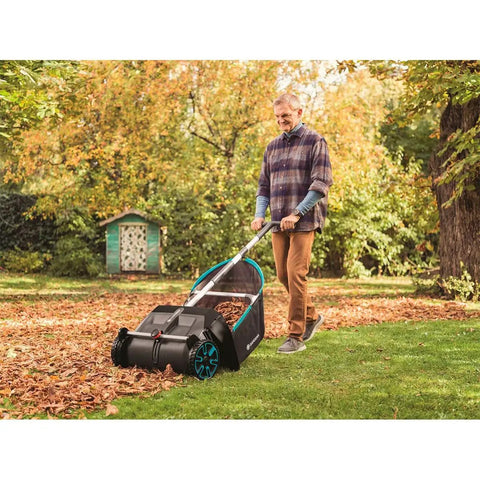 Man using Durable Lawn Sweeper For Leaves And Grass Clippings, No Fuss Maneuvering 3.2 Cu Ft Mesh Hopper, on a lawn