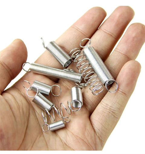 Hand holding multiple heavy duty torsion springs from 200 pcs steel hardware kit for appliances motors lawn equipment universal extension tension springs corrosion resistant