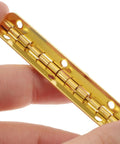 Close-up of Heavy Duty 90 Degree Antique Flush Cabinet Hinges in gold finish held against white background