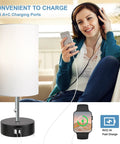Woman with headphones using Three Color Temperature Bedside Lamp With USB A Port And USB C Port; lamp in modern room setting.