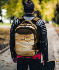Back view of person wearing Green Eye Golden Cat Printed Unisex Backpack With Large Capacity, durable polyester, in a park