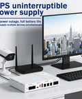 Mini UPS Backup Power Supply 8000mAh Battery Pack For Routers and Modems on desk, powering camera and router with monitor.