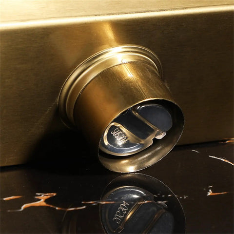 Heavy Duty Gold Linear Shower Drain With Brick Pattern Grate And Built In Hair Catcher For Bathrooms showing close-up of drainage outlet.