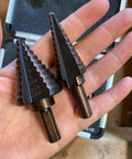 Pro Multi Size Step Drill Kit 5 Piece Hss With Cool Spiral Flute Design For Clean Holes And Less Heat Buildup To Get Your Metal Or Plastic Drilling Projects Done Fast And Super Tough.. two HSS step drill bits in hand