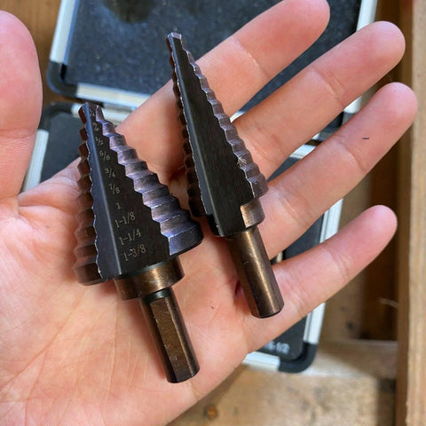Pro Multi Size Step Drill Kit 5 Piece Hss With Cool Spiral Flute Design For Clean Holes And Less Heat Buildup To Get Your Metal Or Plastic Drilling Projects Done Fast And Super Tough.. two HSS step drill bits in hand