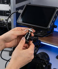 Person attaching Dope Camera Mount Screw Kit For Your Rig with quarter inch to three eighths inch screws to a camera monitor