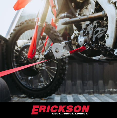 Red 1 Inch By 10 Foot Retractable Ratcheting Tie Down Straps attached securing motorcycle in truck bed.