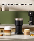 XL Milk Frother With Three Froth Modes For Latte And Cappuccino Hot Foam Cold Foam And Hot Milk 7.6 Oz Foam Capacity 13.5 Oz Hot Milk Dishwasher Safe Easy Clean Ideal Home Barista Tool on a kitchen counter with coffee mugs.