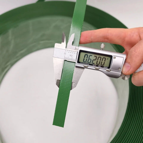 Measuring 5/8 inch width of Heavy Duty Green Polyester Strapping Roll For Solid Pallet Securing 5/8 Inch Wide By 4000 Feet Long.