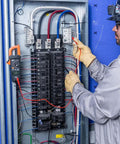 Electrician using Auto Ranging Digital Clamp Meter With True RMS for AC and DC current in electrical panel.