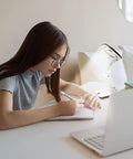 Student using Pocket Magnifier With Light And Stand 3X Magnification Handy Portable 2-In-1 LED Desk Magnifier Visor Folding For Close Work Reading Repair Crafts Hobby For Fine Detail Work for studying at a desk.