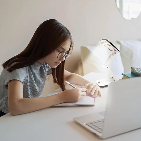 Student using Pocket Magnifier With Light And Stand 3X Magnification Handy Portable 2-In-1 LED Desk Magnifier Visor Folding For Close Work Reading Repair Crafts Hobby For Fine Detail Work for studying at a desk.