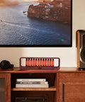 Music Sync LED Light With Spectrum Modes For Desk Use in walnut wood finish, placed on a wooden shelf, glowing in ambient light.