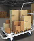 Heavy Duty Foldable Platform Push Cart With Smooth Rolling Rubber Wheels And Slick Stainless Steel Frame loaded with cardboard boxes in warehouse.