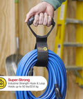 Person holding blue hose bundle with Wrap-It Storage Straps 17-Inch 2-Pack Heavy-Duty Hook And Loop Cord Carrier Hanger