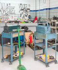 Two blue carts with toolboxes on Three Inch Industrial Cast Iron Casters Set Of Four Heavy Duty Swivel Wheels With 1400 Lb Capacity For Furniture Workbenches And Carts Semi Steel Yokes Durable Galvanized Finish in a workshop.