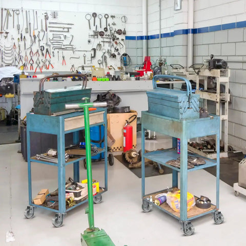 Two blue carts with toolboxes on Three Inch Industrial Cast Iron Casters Set Of Four Heavy Duty Swivel Wheels With 1400 Lb Capacity For Furniture Workbenches And Carts Semi Steel Yokes Durable Galvanized Finish in a workshop.