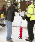 Two people using 8 Inch Nylon Ice Fishing Auger Kit With 14 Inch Extension Rod And Drill Adapter, red, on ice