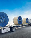 Flatbed truck transporting large cable spools secured with Four Pack Three Eighth Inch Grade 70 Binder Chain With Clevis Grab Hooks.