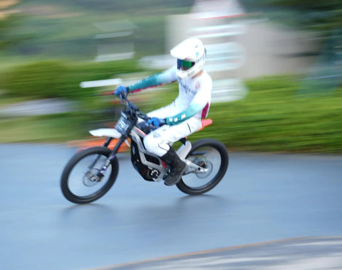 Adult Electric Dirt Bike Built To Shred With Raw Torque And 53 MPH Top Speed racing on a dirt path, showcasing speed and agility.