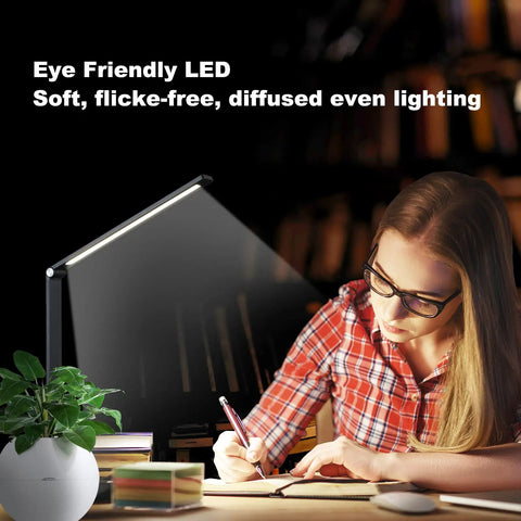 LED Desk Lamp With USB Port For Home Office And Reading, Eye Caring Light With 5 Color Modes And 5 Dimmable Levels, Touch Control And Auto Timer, Piano Style Modern Table Lamp illuminating a desk with a person writing.