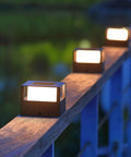 Six Pack Solar Post Lights With 20 Lumen Warm White LED Waterproof Outdoor Post Caps on a wooden fence rail at dusk