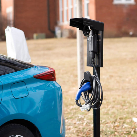Ride-Ready Outdoor EV Charging Pedestal Housing a Tough Steel Hood Shielding Plug-In, with cables secured on solid black frame.