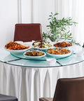 Heavy Duty Slick Spin Tempered Glass Lazy Susan Turntable with various dishes on a dining table for family feasts.