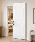 Zero Hassle Concealed Barn Door With Butter Smooth Soft Close Glide And Show Stopper Two Panel Raised Arch Design In Crisp White Primer For Quick Room Refreshes, displayed in interior setting.