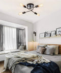 Industrial Semi Flush Mount Four Light Ceiling Fixture With Adjustable Black Metal Branches in a modern bedroom setting.