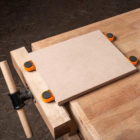 Set Of 8 19mm Nylon Bench Dogs For Woodworking, non marring workbench pegs securing a board on a wooden table.