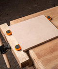 Heavy Duty Three Quarter Inch Aluminum Workbench Dogs Eight Pack With Grippy Pads securing a MDF board on a wooden workbench.