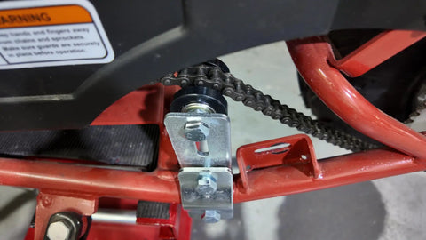 Close-up view of the Slick Upgraded Heavy Duty Chain Tensioner Adjuster with 8MM Steel Guide Wheel attached to a motorized bike.