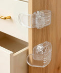 Six Pack Clear Baby Drawer Locks Zero Sweat Install for thin drawers, showing smooth push button design and grip.