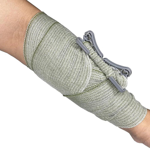 Rhino Rescue 6-inch Israeli-style emergency bandage wrapped forearm; olive-green compression wrap with gray fasteners.