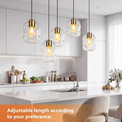 3 Pack Gold Pendant Lights For Kitchen Island Featuring 8.7 Inch Hand Blown Clear Art Glass Globes over a modern kitchen island.