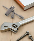 Must-Have Stainless Steel Trailer Jack Drill Adapter with wrench and hex bits on wooden surface for RV leveling and scissor jacks.