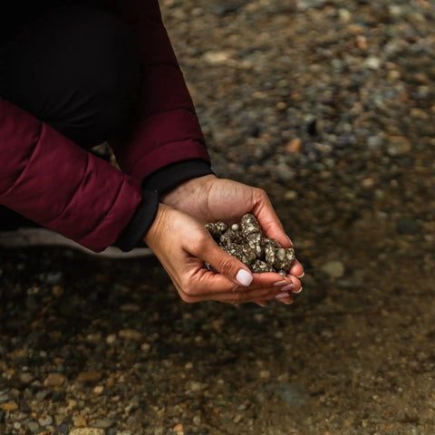 Hands holding mineral stones replacement for gravity water system, adds calcium magnesium phosphorus potassium for mineral rich water