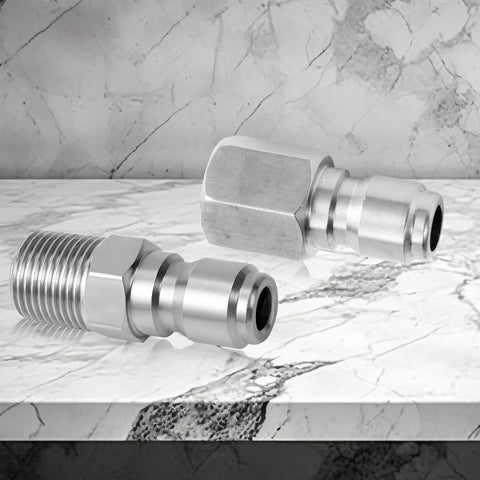 Stainless steel 1/4-inch quick-connect pressure washer fittings (2) on marble with internal and external threads.