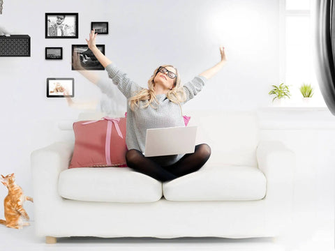 Woman using laptop on white sofa with cat; Hands Free Z Wave Gesture Controller for Smart Homes, No Touch Swipe Pad in background.