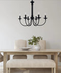 Indoor Candle Chandelier 26.5 Inch in Rubbed Oil Bronze above dining table with chairs, featuring upward candle stem lights.