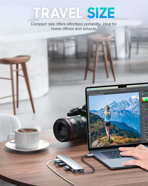 7 In 1 USB C Hub For MacBook And USB C Laptops With 4K HDMI 100W Power Delivery USB 3 0 Ports SD And TF Card Reader Space Gray Boss Level USB C Dock For Office Meetings Travel And Home Setup, placed on a desk with a laptop and camera.