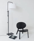 Mid Century Modern Floor Lamp With Ultra Stable Heavy Base And LED Lighting For Bedroom Living Room Or Office Sleek Black Contemporary Standing Lamp That Brings A Clean Cozy Vibe To Any Modern Decor next to black chair.