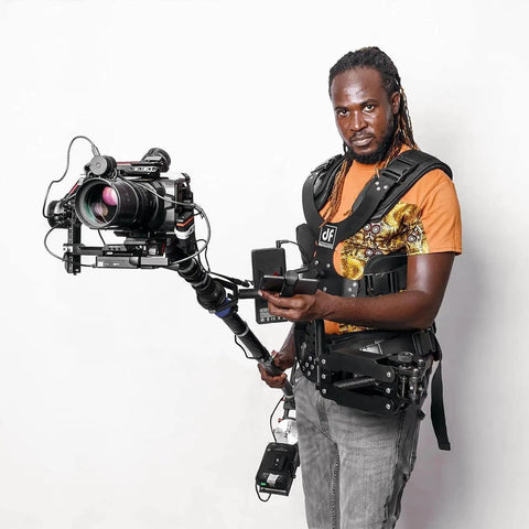 Person wearing Thanos Pro II Vest Stabilizer And Axis System For Gimbals And Rotating Monopod, holding a camera setup.
