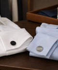Two Pair Silver Plated French Cufflinks For Men Highlighting Smooth Black Enamel Disks And Crisp Grid Mesh Patterns on white and blue dress shirts.